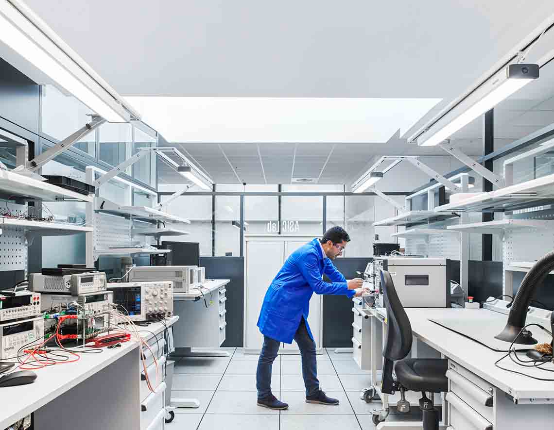 Photo of man in blue lab coat woking in lab (Tier 1_Lab_Clamart_OAT_0476 )