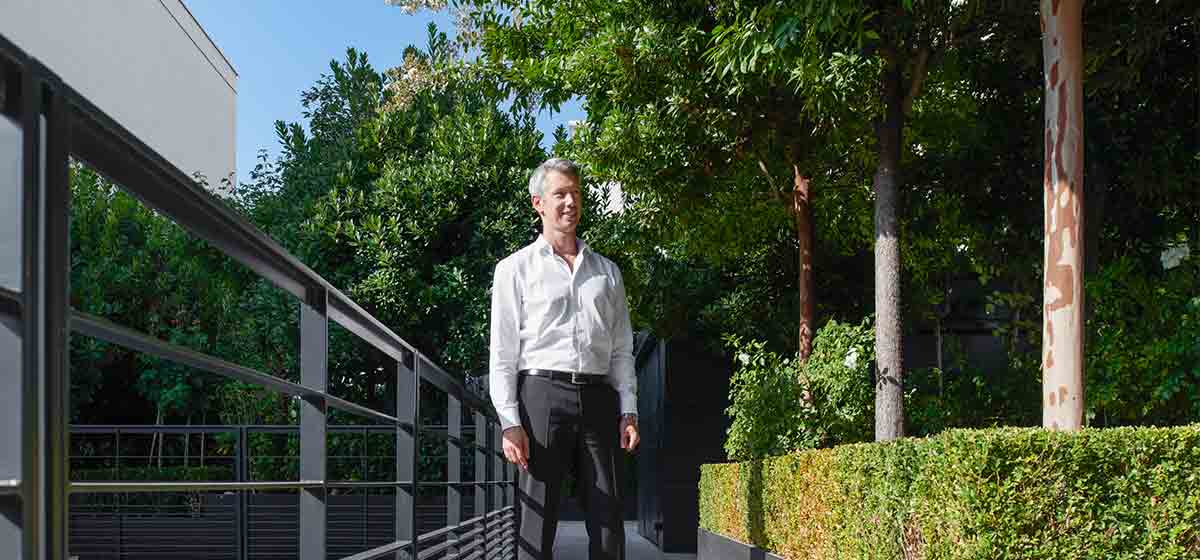 Man standing in green space outside office building (Tier 1_Office_Paris_OAT_13811)