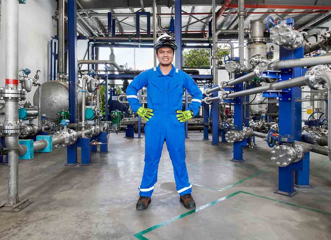 Man in blue coveralls standing in facility  (Tier 1_ManufacturingFacility_Singapore_ASIA_15881)
