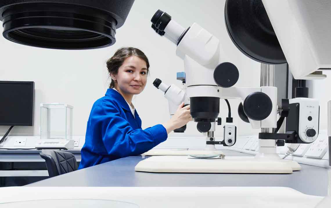 Woman working in a science lab with microscopes