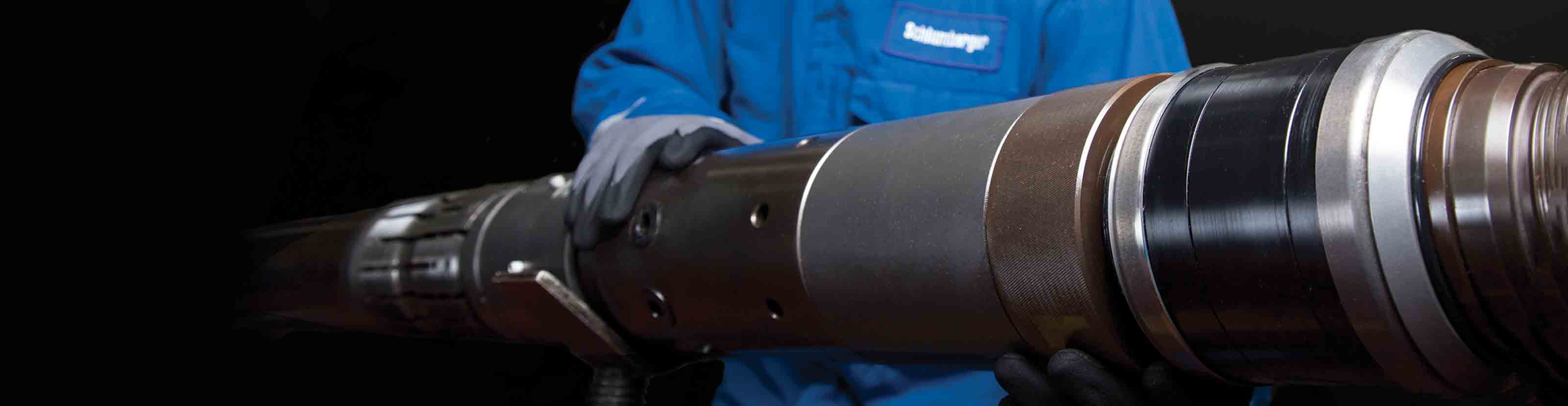 Schlumberger working with hand on the downhole reservoir testing tool.