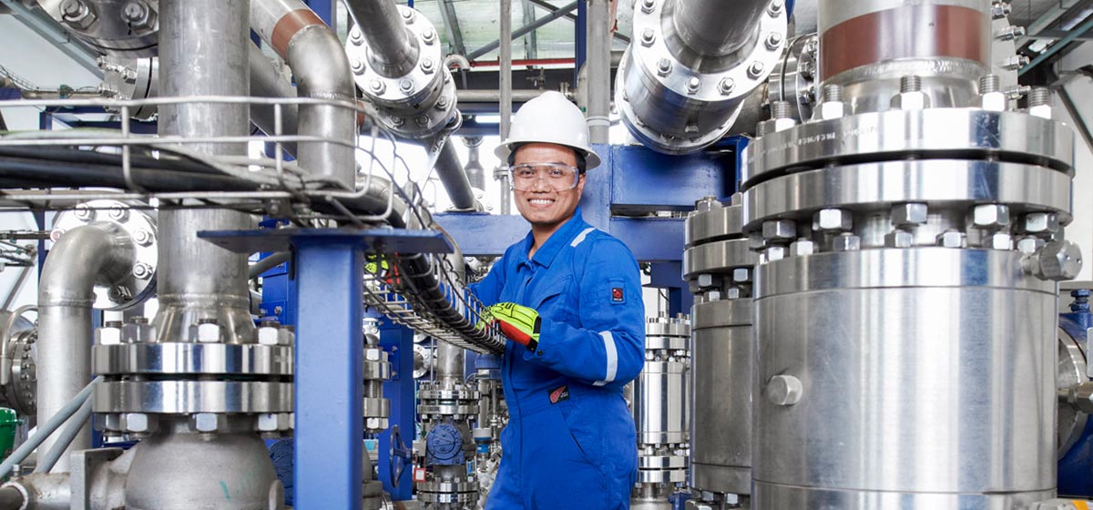 Engineer smiling among valves and machinery